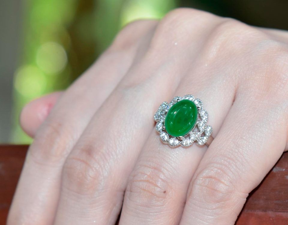 Inel cu piatra verde purtat pe degetul inelar.